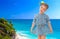 Little girl in a short blue dress on a sea background.