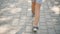 A little girl in shorts is walking in the summer city. The legs of a little girl. Close-up. Slow motion