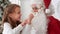 Little girl showing Santa Claus a magic trick with a disappearing finger