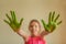 Little girl shows hands that painted green paint