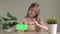 Little girl shows phone with green screen and making heart symbol with her hands