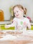 Little girl sifts flour