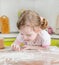 Little girl sifts flour