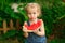 Little girl sit on watermelon and eating pieces