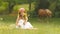 Little girl sits in a clearing, turns over the torn wild flowers and makes a bouquet from them. Slow motion