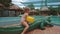 Little Girl Sits down on Toy Crocodile by Pool at Hotel