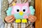 Little girl sits and holds an owl toy in the hands. Cute pink and blue felt toy. Home felt decor