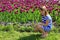 Little girl sits by lilac tulips