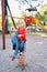 Little girl sits on a spring swing-balancer in the park