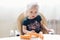 Little girl sits on a table and eats a carrot