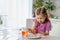 Little girl sits at table and paints eggs. baby is afraid that she will drop egg