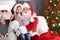 Little girl sitting on authentic Santa Claus` lap