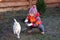 Little girl sitting crouched beside dog