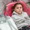 A little girl sitting in a dental chair prepared for the procedure, the child has an apron on his chest from the dirt.