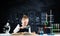 Little girl sitting at desk with magnifier