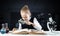 Little girl sitting at desk with magnifier