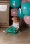 Little girl sitting on the floor in the room next to the balloons, first birthday, celebrate. one year old blue and pink balls wit