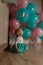 Little girl sitting on the floor in the room next to the balloons, first birthday, celebrate. one year old blue and pink balls wit