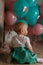 Little girl sitting on the floor in the room next to the balloons, first birthday, celebrate. one year old blue and pink balls wit