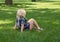 Little Girl Sitting in Green Grass with Knees Bent