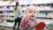 Little girl sitting in a grocery cart and waiting for mom