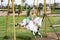 Little girl sitting on harseback of children swing, swinging on playground