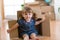 Little girl sitting inside cardboard box in her new home
