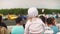 Little girl sitting on parent`s shoulders and looking at car show