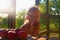 Little girl is sitting on porch in summer. Small girl is eating apples. Apples on table. Dreamy and romantic image