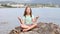 Little girl sitting on a rock and meditates