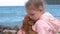 Little girl sitting on the rocks with her sweet puppy