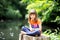 Little girl sitting on stump