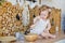 A little girl is sitting on a table in a bright Scandinavian-style kitchen. Playing with dishes  cereals  beans. The concept of