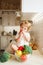 Little girl sitting on the table and eats tomato