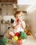 Little girl sitting on the table and eats tomato