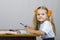 Little girl sitting at the table and wrote in a notebook