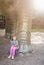 Little girl sitting under huge Diplodocus dinosaur sculpture