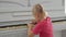 A little girl sitting at a white piano presses the keys.