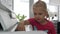 A little girl sitting at a white piano presses the keys.