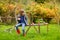 Little girl sitting on a wooden bench on autumn