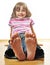 Little girl sitting on a wooden floor