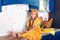 Little girl sitting on work surface of kitchen waiting for breakfast. Cheerful and mischievous girl in kitchen. Healthy nutrition,