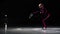 A little girl skater in a black sports suit and white skates performs a spinning stand in the arena of the ice stadium