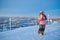 Little girl-skier on the hill watching the sunrise