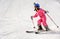 Little girl skiing fast downhill