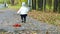Little girl in skirt walking in autumn park