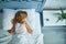 Little girl sleeping on a big and cozy bed white linen in the afternoon at home