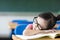 Little girl is sleeping while wearing glasses in the classroom