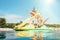 Little girl sliding down into sea water from floating Playground slide Catamaran as she enjoying sea trip with her sister and