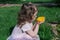 Little girl smell bright yellow flower at spring time